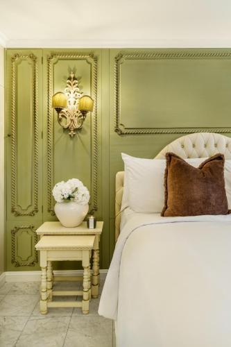 a bedroom with a bed and a table with a vase of flowers at Hotel Bardot Boutique in Panama City