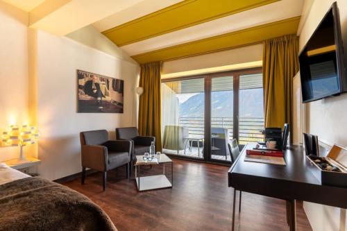 a hotel room with a bed and a desk at Hotel Gartner in Tirolo
