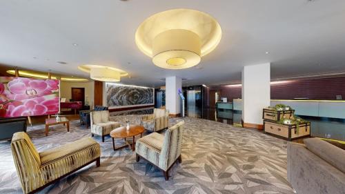 a lobby of a hotel with chairs and a table at Hilton London Heathrow Airport Terminal 5 in Hillingdon