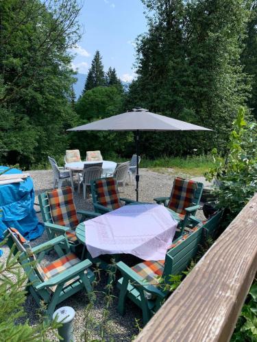 an outdoor table and chairs with an umbrella at 400 year old wooden house in Bad Goisern