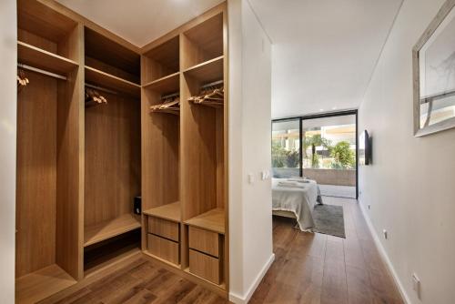 a room with wooden closets with a bed in the background at Del Mar Apartment - BT in Olhão