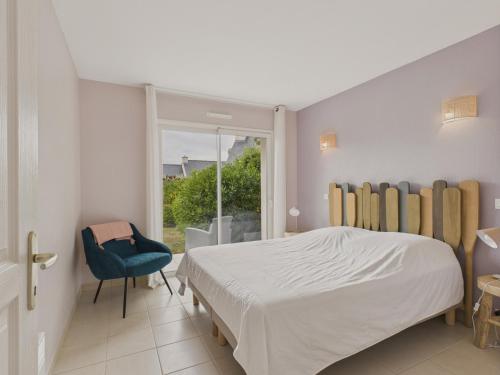 une chambre avec un lit, une chaise et une fenêtre dans l'établissement À 200m des plages - Maison pour 8 - Vue mer, à Saint-Gildas-de-Rhuys