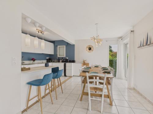 une cuisine avec des murs bleus et une table et des chaises dans l'établissement À 200m des plages - Maison pour 8 - Vue mer, à Saint-Gildas-de-Rhuys