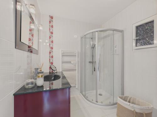 une salle de bain blanche avec une douche et un lavabo dans l'établissement À 200m des plages - Maison pour 8 - Vue mer, à Saint-Gildas-de-Rhuys