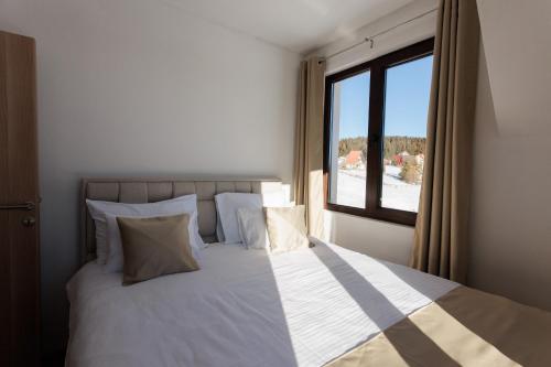 a bedroom with a large bed with a window at Vila Oaza mira Golija in Golija