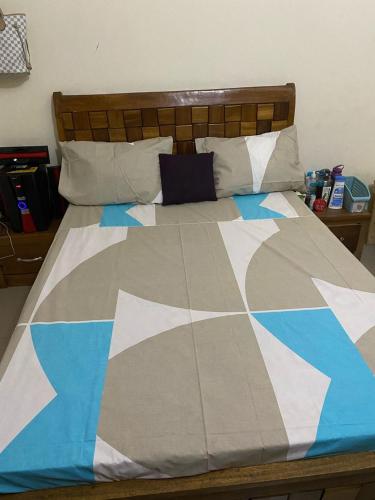 a bed with a blue and white comforter on it at Bintas Bed and Breakfast in Sukuta