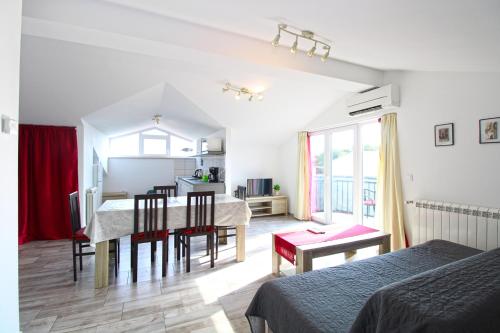 a kitchen and dining room with a table and chairs at Apartments Tamara 2397 in Fažana