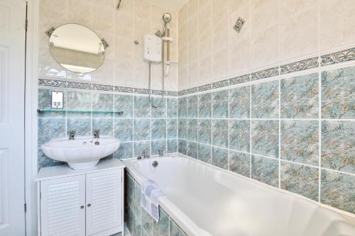 a bathroom with a bath tub and a sink at The Wishing Well- Lovely Spacious Home In BS4 Sleeps 8 By STAE- Homes in Bristol
