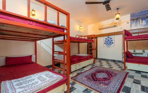 a room with three bunk beds in a room at Travellers Village-City Center Hertige Home in Jaipur