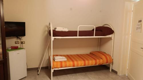 a small room with two bunk beds and a television at Domus Case Vacanze civico del mare in Castellammare del Golfo