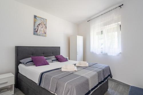 a bedroom with a large bed with purple pillows at Villa DE Luna Istra,whirlpool in Barban