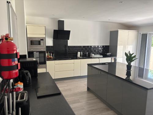 a kitchen with white cabinets and a black counter top at Kane's Place in Birkenhead