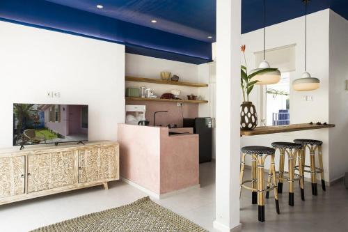 a kitchen with a counter and stools in a room at KAME HOUSE - Peaceful Villa near Bali Safari in Keramas