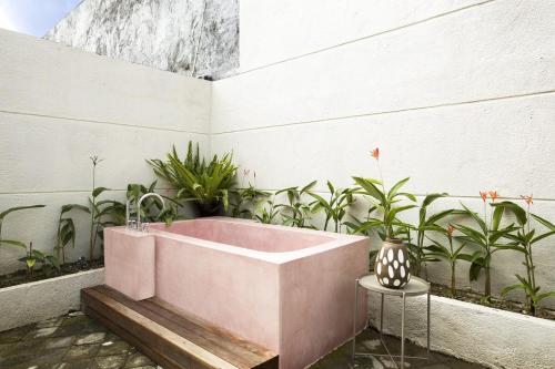 a pink bath tub in a courtyard with plants at KAME HOUSE - Peaceful Villa near Bali Safari in Keramas