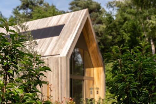 a small wooden house with a window in a forest at Lodge - 6 personen - Woodz Lodges in Heusden - Zolder