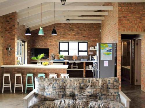 a living room with a couch and a kitchen at Low Tide 8 Sleeper in Agulhas