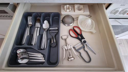 a lunch box with utensils and a tray with scissors at Voll ausgestattet, Nähe Heiltherme Bad Waltersdorf in Ebersdorf