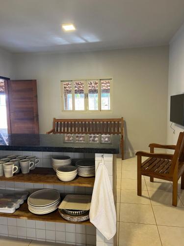 a kitchen with a counter with plates and dishes at Casa das Orquídeas Delfinopolis MG in Delfinópolis