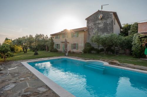 a swimming pool in front of a house at Dobrinja Residence Villas Lopar in Marezige