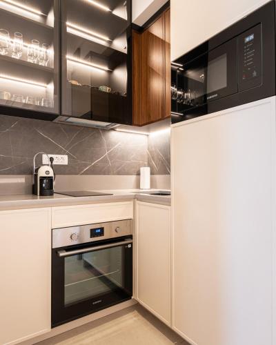 a kitchen with white cabinets and a refrigerator at Elysium Tivat in Tivat