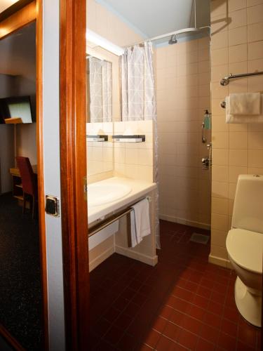 a bathroom with a sink and a toilet at Hotel Savoy in Mariehamn