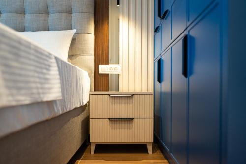 a bedroom with a bed with a nightstand and a blue door at Elysium Tivat in Tivat