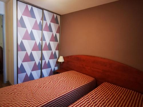 - une chambre avec 2 lits et un mur coloré dans l'établissement Duplex 7 Pers avec Piscine Couverte, Fitness et Parking, à 400m des Pistes et Proche Centre - FR-1-404-256, à La Mongie