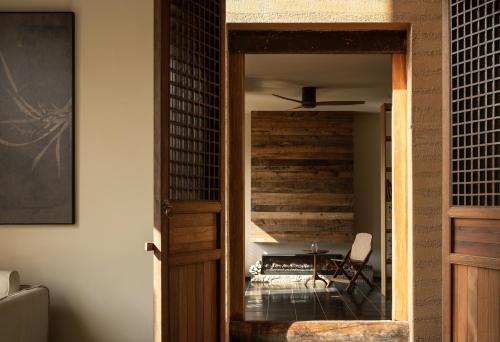 a room with a wooden door and a table with a chair at Hegu Retreat Qingcheng in Jiezi Ancient Town