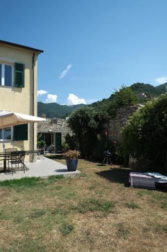 a patio with a table and an umbrella in a yard at Rapallo La Vista by PortofinoVacanze in Rapallo
