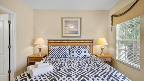 a bedroom with a bed and two lamps and a window at SHVCK5 - Coral Cay Resort #5 - 4 Bed 3 Baths Townhome in Kissimmee