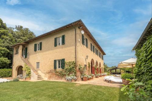 a large brick building with a patio and a yard at Centolivi 8 by Salogi Villas in Montecastello