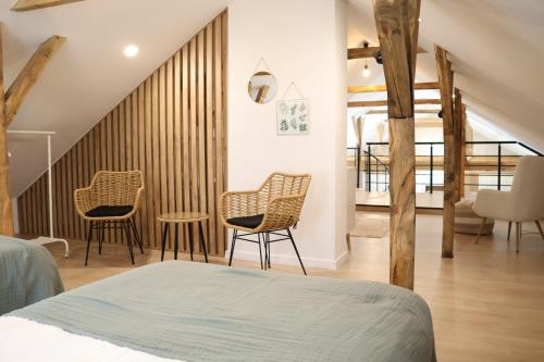 a bedroom with two chairs and a staircase at Dom w lesie przy stawach in Dylewo