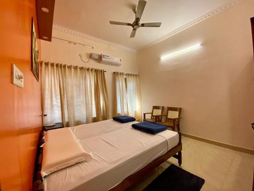 Un dormitorio con una cama y un ventilador de techo. en Sree Padmanabha Heritage, en Trivandrum