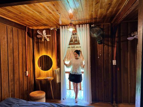 a woman is walking out of a window at Lagom Bắc Hà Farmstay in Lao Cai