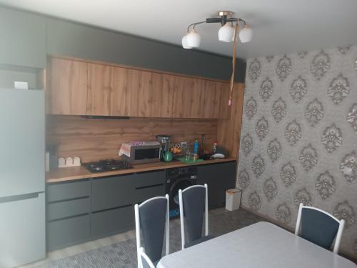 a kitchen with a counter and a table with chairs at Домашний уют in Akchiy