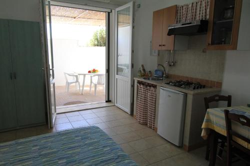 a kitchen with a door open to a patio at B&B Monterossi in Torre Vado