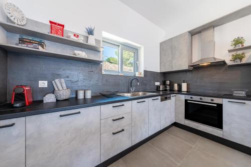 a kitchen with white cabinets and a sink at Costa Mediterranea in Gaios