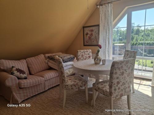 a living room with a couch and a table with chairs at Sunny Hill Apartment in Smętowo Chmieleńskie