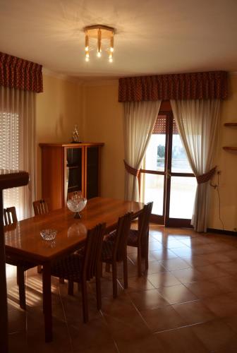 a dining room with a wooden table and chairs at Casa Alfieri in Paestum