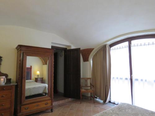 a bedroom with a mirror and a bed and a dresser at Relais Palazzo Paleologi Sec.XIV in Lu