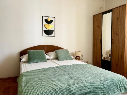 Un dormitorio con una cama con un edredón verde. en Mina Penthouse, en Novi Sad