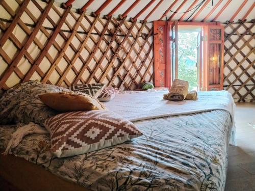 1 cama grande en una yurta con ventana en Le Ptit Mas, en Salernes