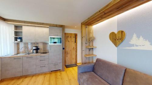 a living room with a couch and a kitchen at Hotel - Restaurant - Sonnblick in Heiligenblut