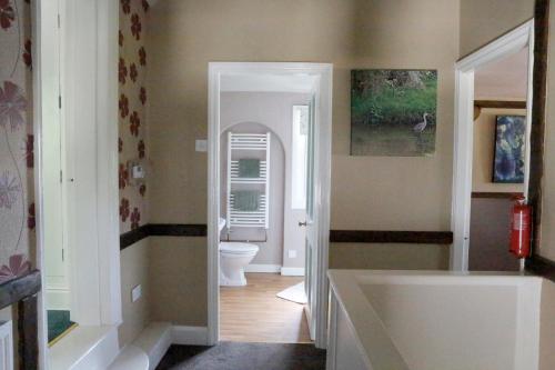 a bathroom with a tub and a toilet at Country Mansion - Private Annexe in Llanwrda