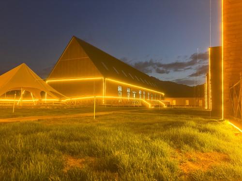 a large building with a pointed roof at night at Fengchui Banxia Manor Wild Luxury Camp in Taxkorgan