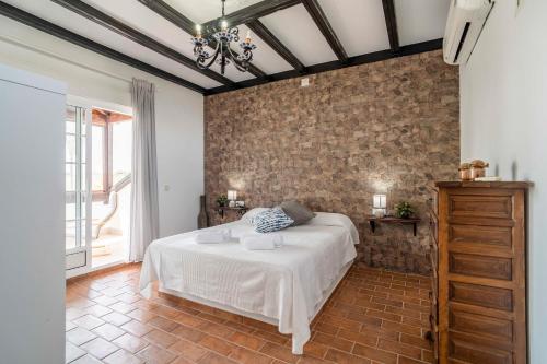 ein Schlafzimmer mit einem Bett und einer Ziegelwand in der Unterkunft Casa Rural La Perla in La Puebla de Cazalla