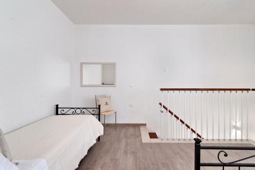 a white bedroom with a bed and a staircase at Salento Rosa dei Venti - Lecce Selection in Surbo