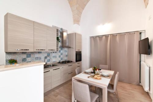 a kitchen with a white table and chairs in a room at Salento Rosa dei Venti - Lecce Selection in Surbo