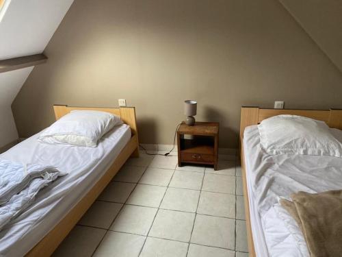 a bedroom with two beds and a table with a lamp at LE PRESSOIR GITE 4-6pers, piscine, billiard et baby-foot in Sainte-Hélène