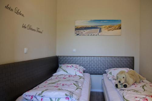 a dog laying on two beds in a room at Inselblume 49 - Ferienwohnung im Erdgeschoss der Strandburg in Burgtiefe auf Fehmarn 
